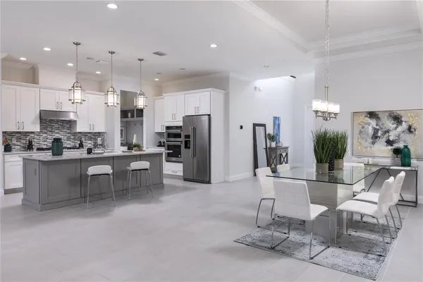 a kitchen with stainless steel appliances kitchen island granite countertop a refrigerator and cabinets