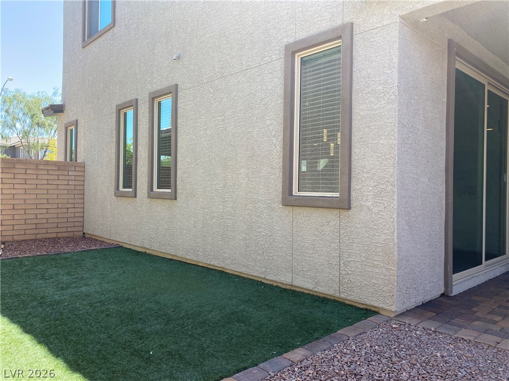 436 Cadence View Way Henderson, NV 89011 - Photo 34 of 36 A compact yard offers low-maintenance turf and a privacy wall, perfect for outdoor living.