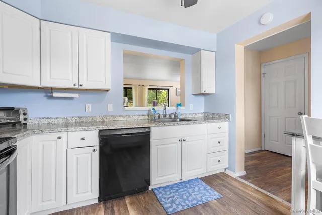 a kitchen with granite countertop white cabinets and sink
