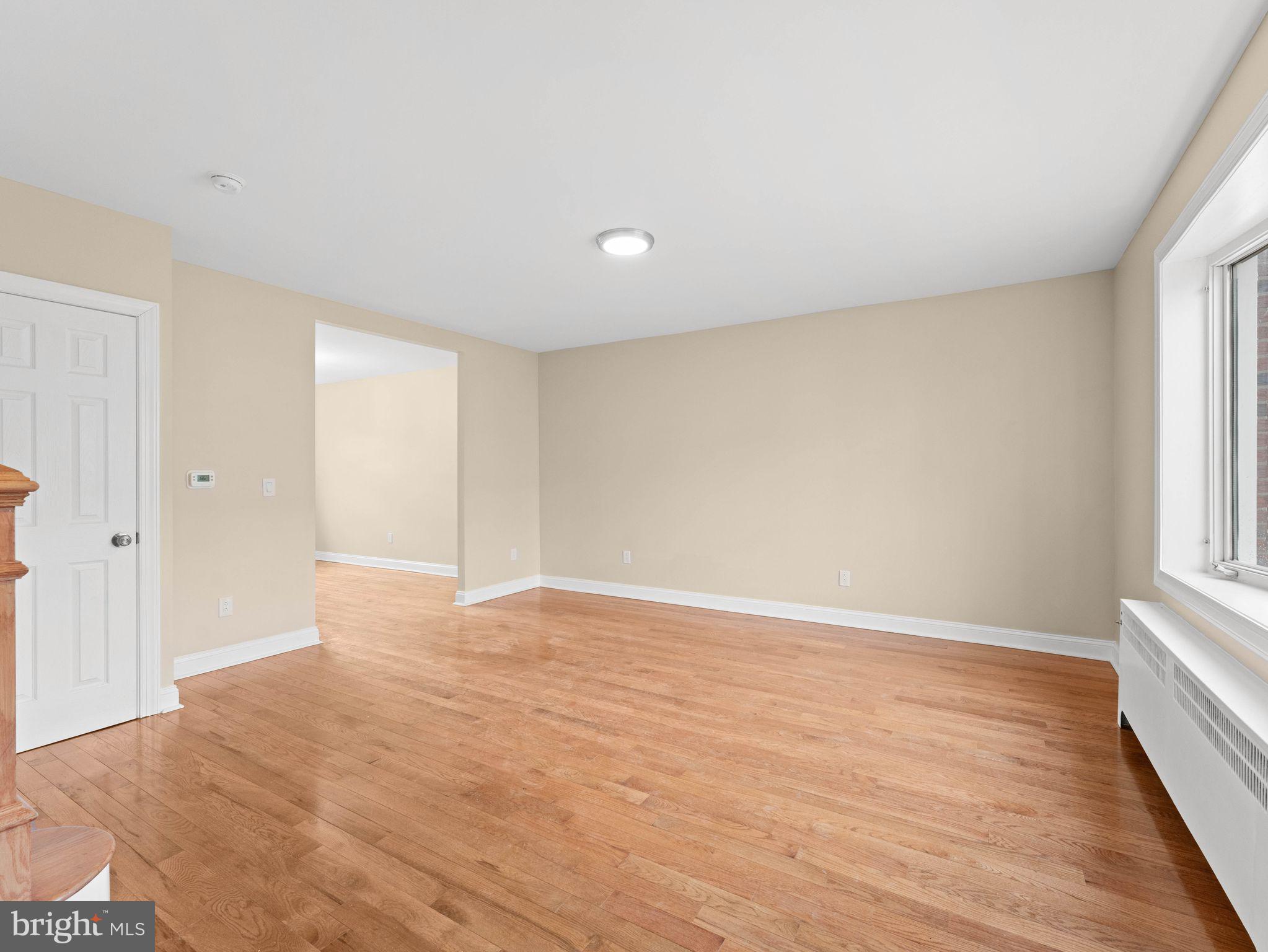 7510 Rugby Street Philadelphia, PA 19150 - Photo 2 of 22 a view of an empty room with wooden floor and a window