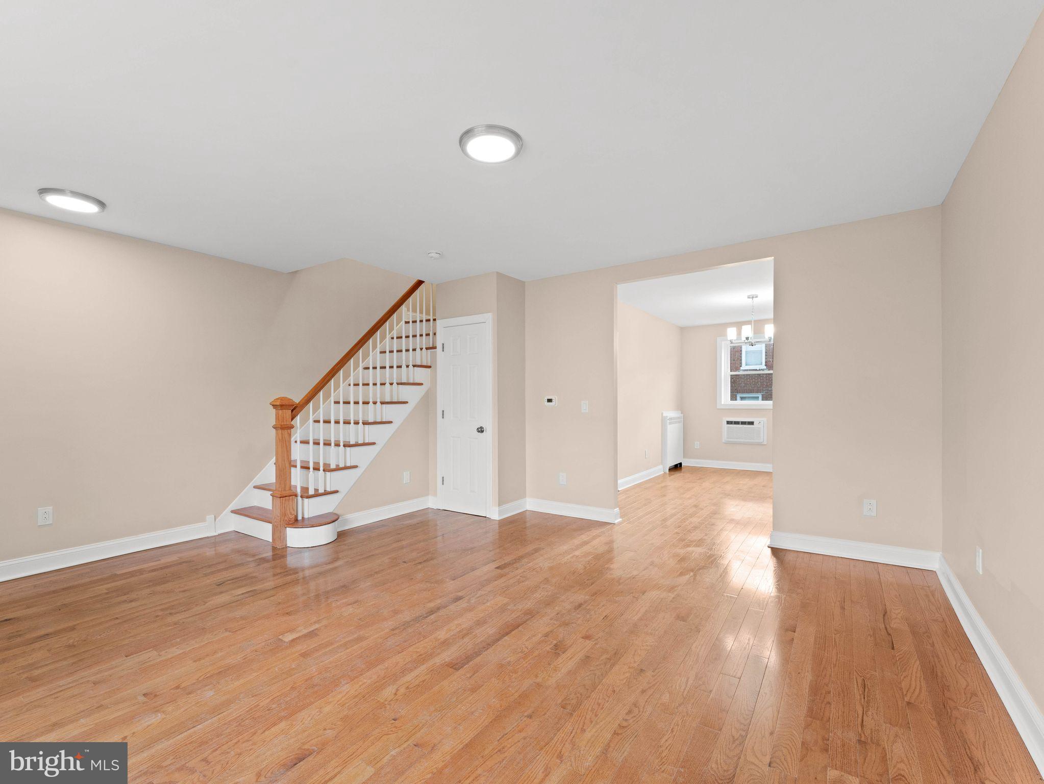 7510 Rugby Street Philadelphia, PA 19150 - Photo 3 of 22 a view of an empty room with wooden floor and stairs