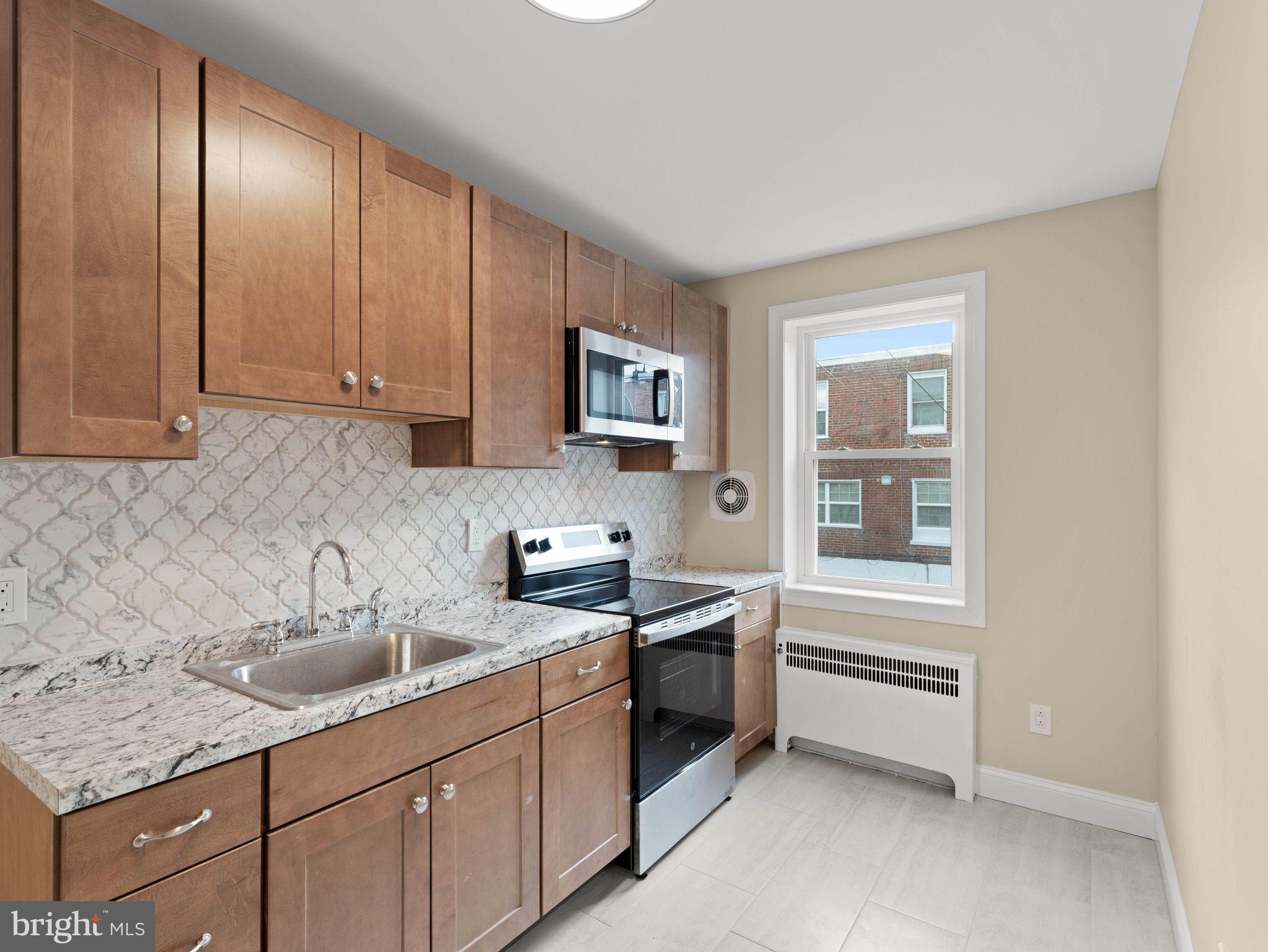 7510 Rugby Street Philadelphia, PA 19150 - Photo 5 of 22 a kitchen with a sink cabinets and window
