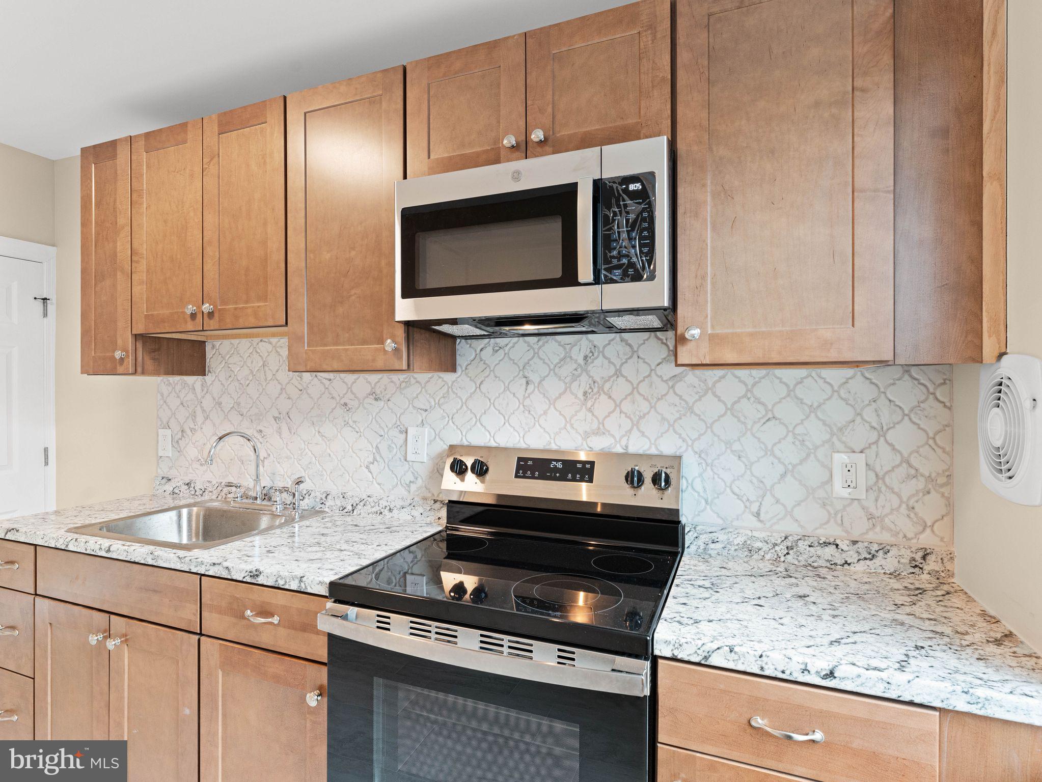 7510 Rugby Street Philadelphia, PA 19150 - Photo 6 of 22 a kitchen with a stove and a microwave
