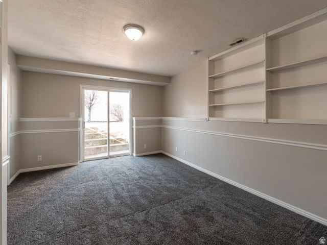 1446 West 1450 North Layton, UT 84041 - Photo 15 of 16 Spacious room featuring gray carpet, built-in shelving, white chair rail molding, and a sliding glass door providing external access