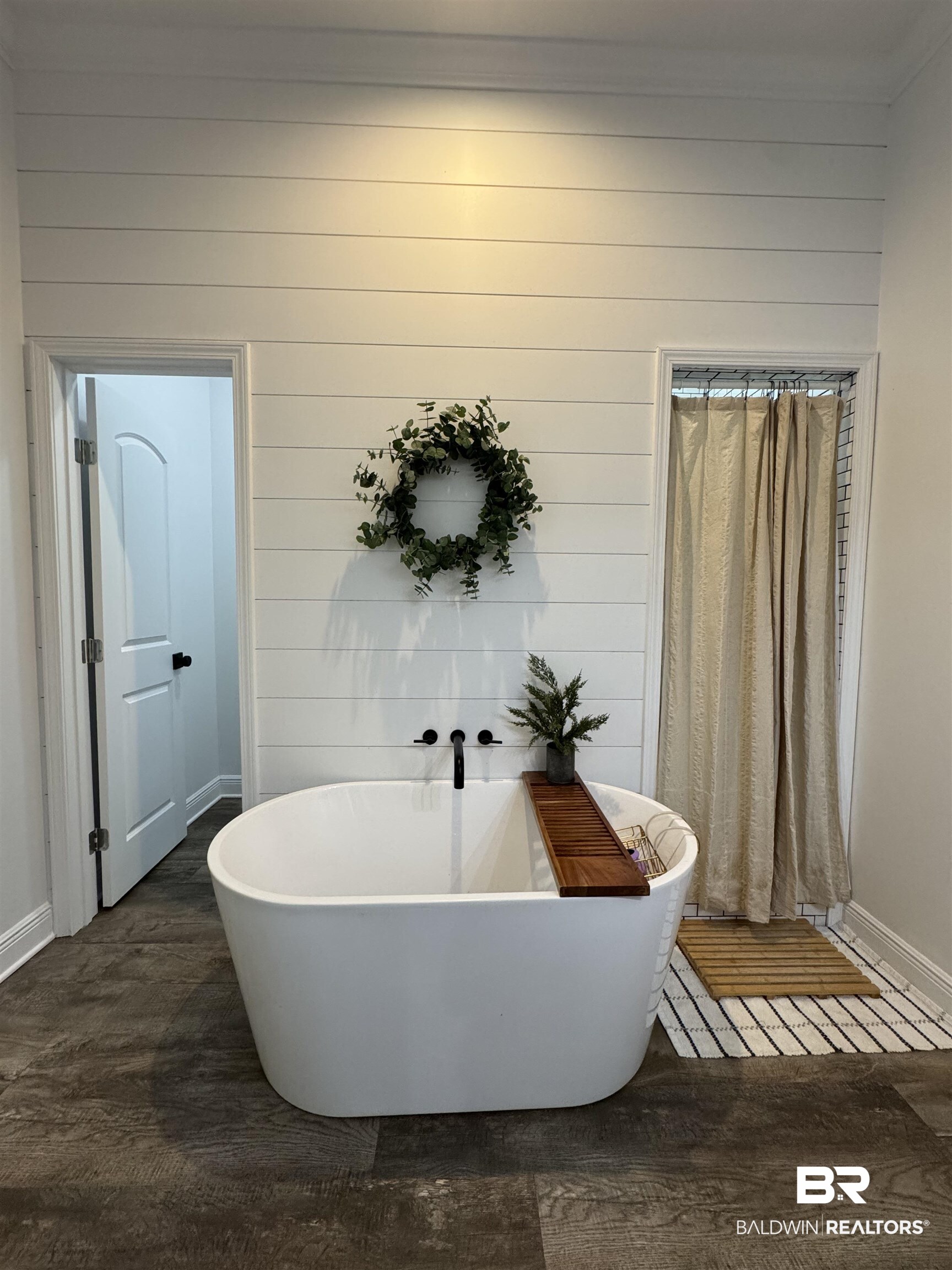 370 Dianne Road Frisco City, AL 36445 - Photo 31 of 41 Bathroom featuring wood walls, hardwood / wood-style flooring, and a bathing tub