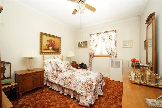 a bedroom with a bed dresser and window