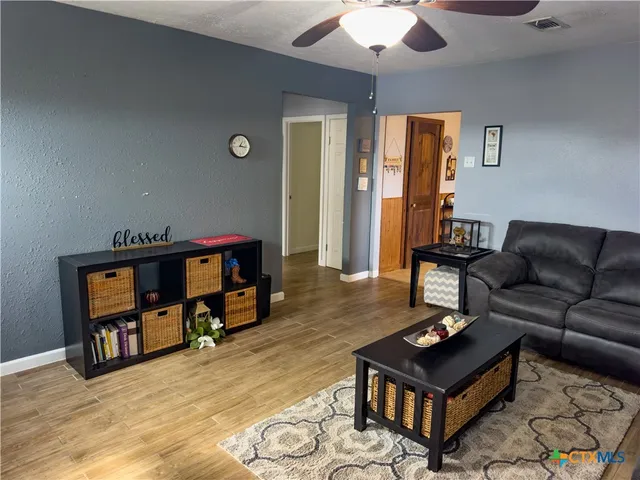 a living room with furniture and a wooden floor