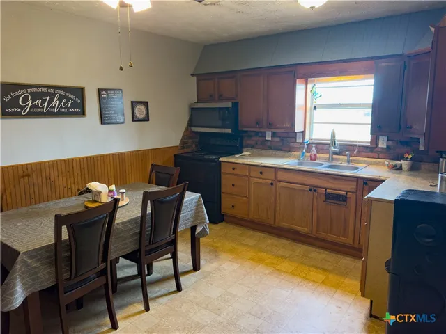 a kitchen with a table chairs sink and cabinets
