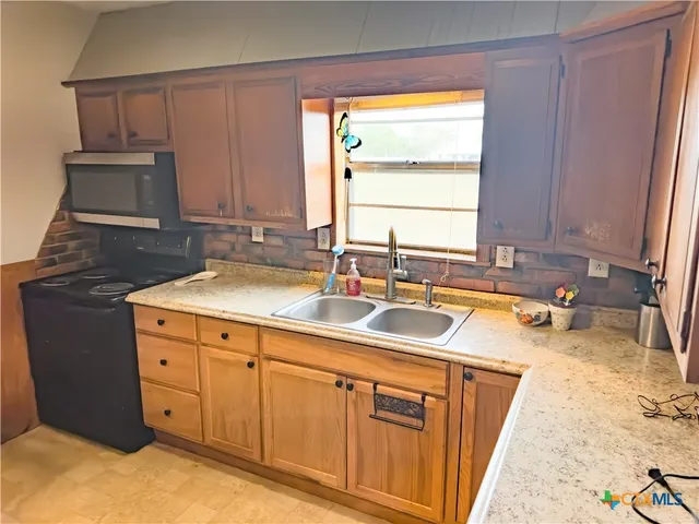 a kitchen with sink cabinets and window