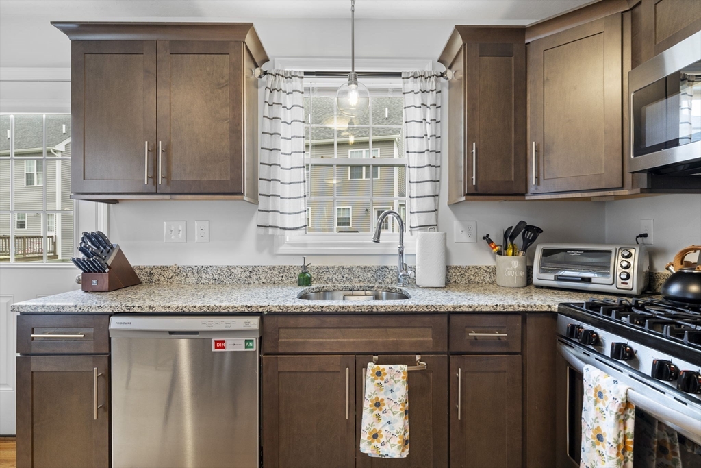 74 Riley Road, Unit 88 Tyngsboro, MA 01879 - Photo 5 of 31 a kitchen with granite countertop a sink stainless steel appliances and cabinets