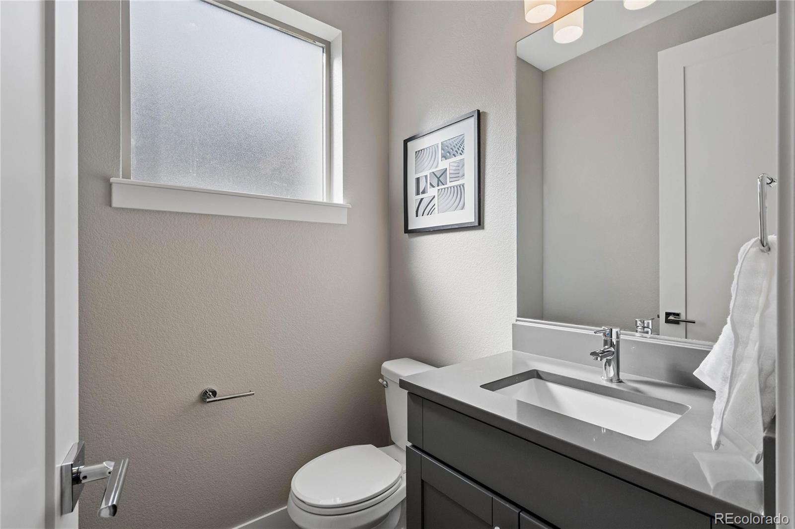 5366 Allison Street, Unit D Arvada, CO 80002 - Photo 20 of 28 a bathroom with a granite countertop toilet sink and mirror