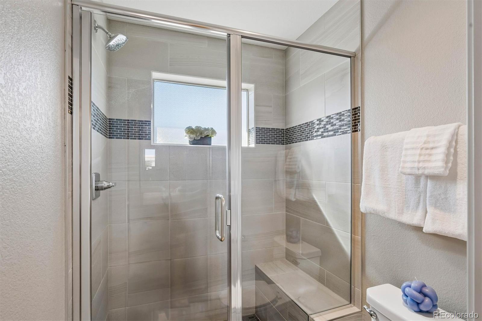 5366 Allison Street, Unit D Arvada, CO 80002 - Photo 22 of 28 a bathroom with a glass shower door and a mirror
