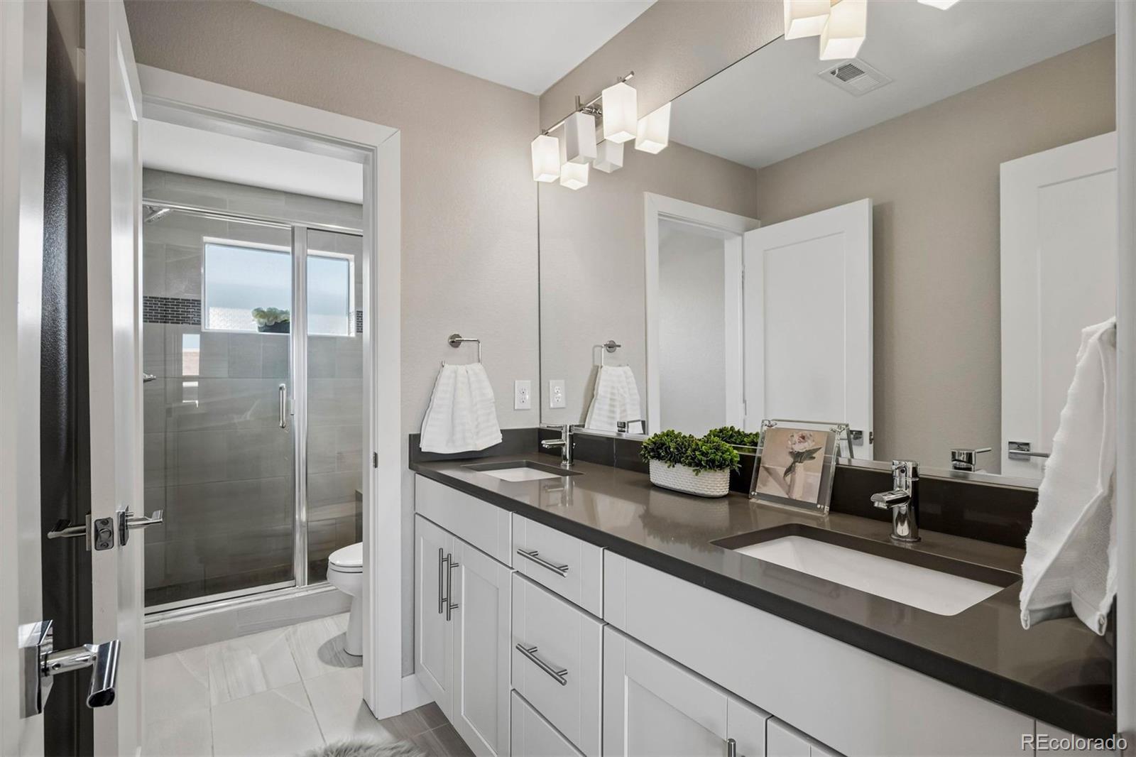 5366 Allison Street, Unit D Arvada, CO 80002 - Photo 5 of 28 a bathroom with a double vanity sink and a mirror