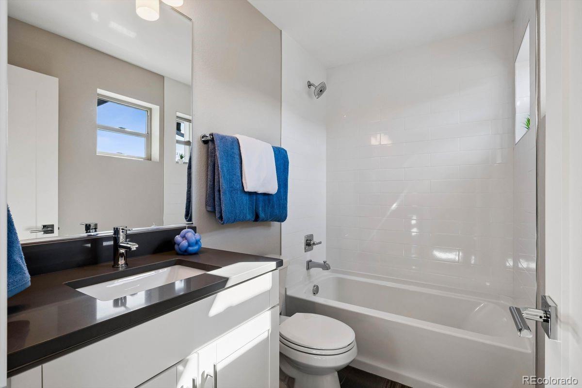 5366 Allison Street, Unit D Arvada, CO 80002 - Photo 7 of 28 a bathroom with a granite countertop sink a toilet a mirror and shower
