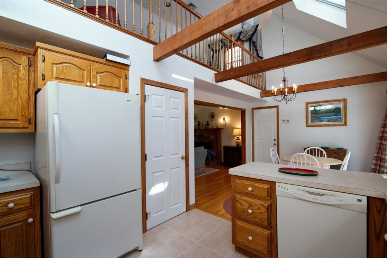 43 Piney Road Cotuit, MA 02635 - Photo 14 of 31 a hallway with a refrigerator a washer and dryer