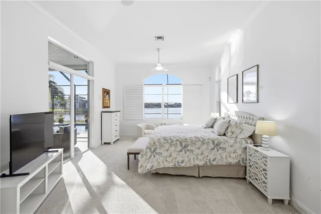 a spacious bedroom with a bed and a flat screen tv