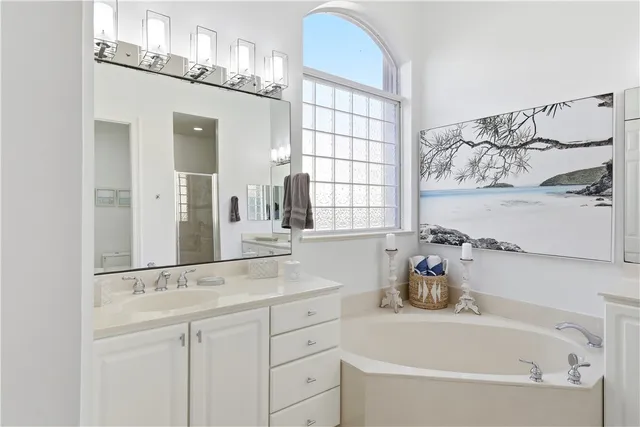 a bathroom with a tub sink and mirror