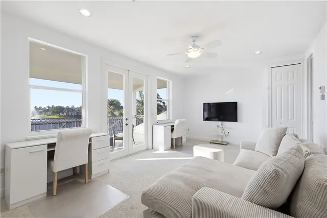 a living room with furniture a flat screen tv and a large window