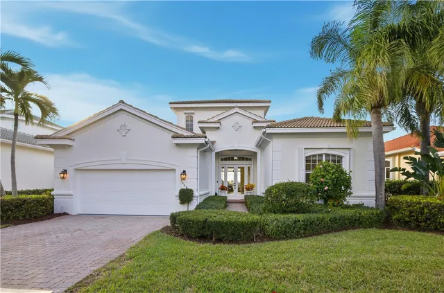 a front view of a house with a garden and plants