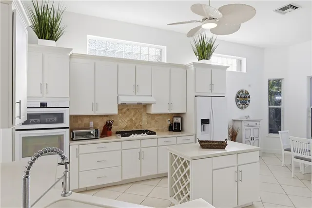a kitchen with a white cabinets and window