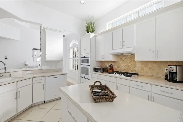 a kitchen with cabinets appliances a sink and a counter top space