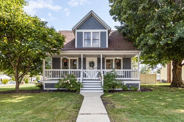 a front view of a house with a garden and trees