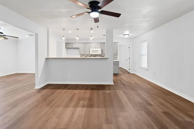 a view of kitchen and hall with wooden floor