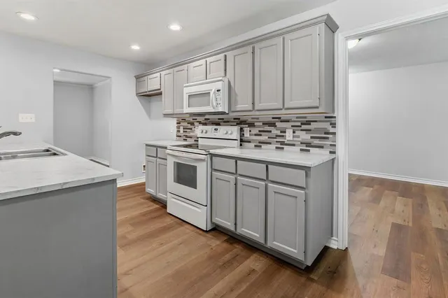 a kitchen with white cabinets sink and stainless steel appliances