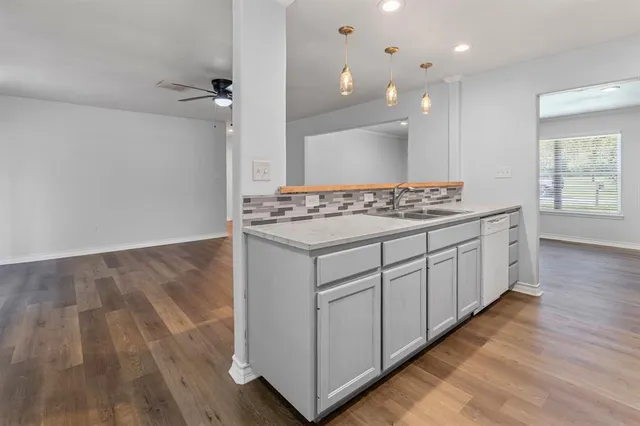 a kitchen with stainless steel appliances granite countertop a stove and a wooden floors