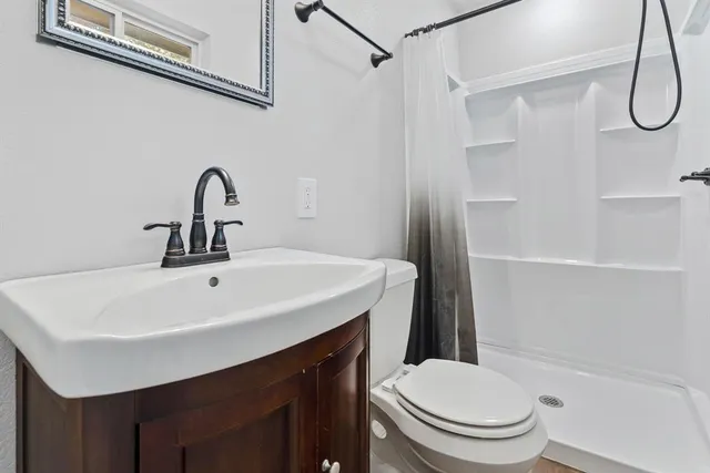 a bathroom with a sink a toilet and shower