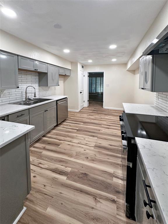 2301 Ridgmar Plaza, Unit 5 Fort Worth, TX 76116 - Photo 15 of 20 Kitchen with decorative backsplash, black electric range oven, gray cabinets, light wood finished floors, and light stone countertops