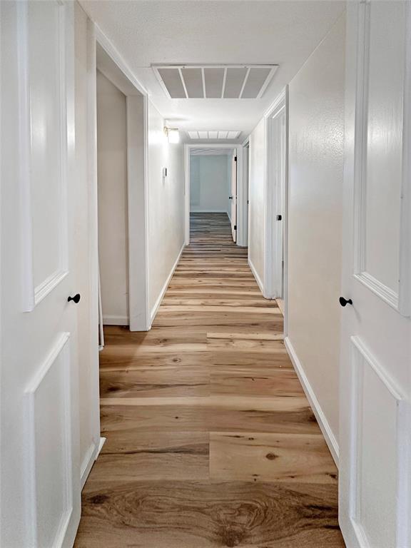 2301 Ridgmar Plaza, Unit 5 Fort Worth, TX 76116 - Photo 8 of 20 Hallway featuring light wood-type flooring and baseboards