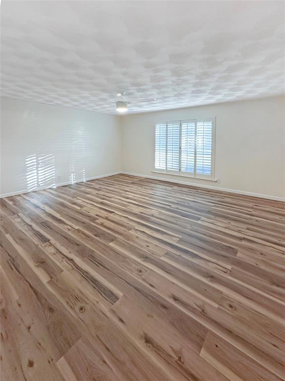 2301 Ridgmar Plaza, Unit 5 Fort Worth, TX 76116 - Photo 9 of 20 Primary bedroom featuring wood finished floors and baseboards
