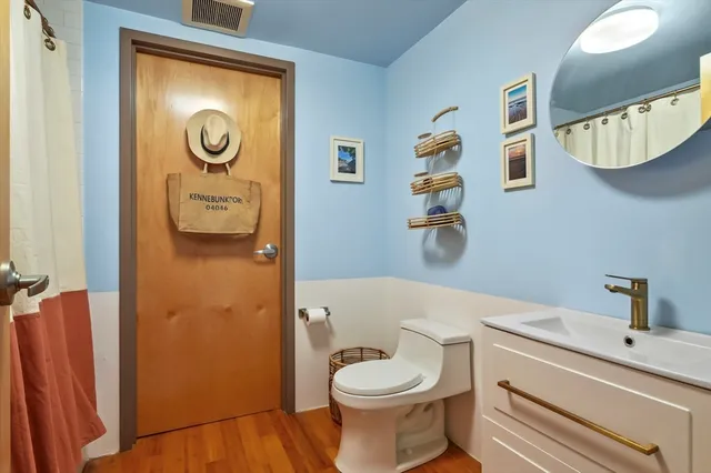 a bathroom with a toilet sink vanity and mirror