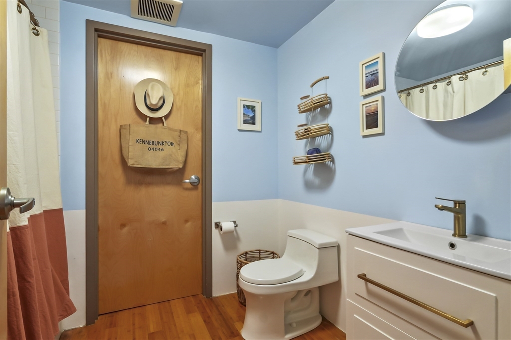 156 Porter Street, Unit 246 Boston, MA 02128 - Photo 16 of 25 a bathroom with a toilet sink vanity and mirror