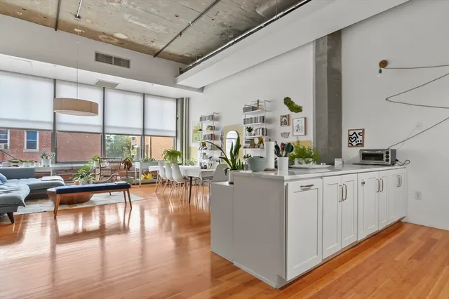 a living room with furniture large window and wooden floor