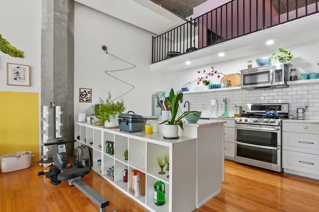 a kitchen with stainless steel appliances a stove a chimney a sink and cabinets