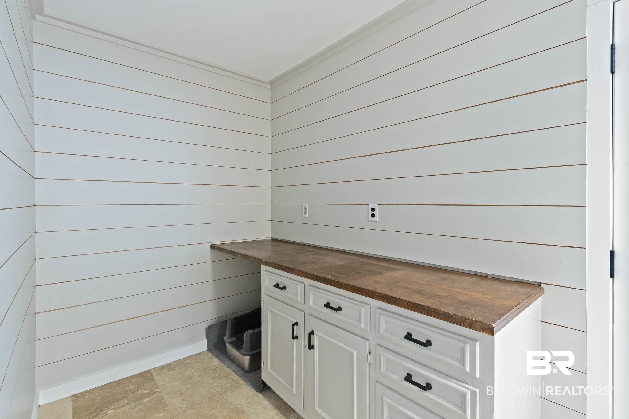 608 Southern Way Daphne, AL 36527 - Photo 30 of 35 Kitchen with butcher block countertops, white cabinets, and wood walls