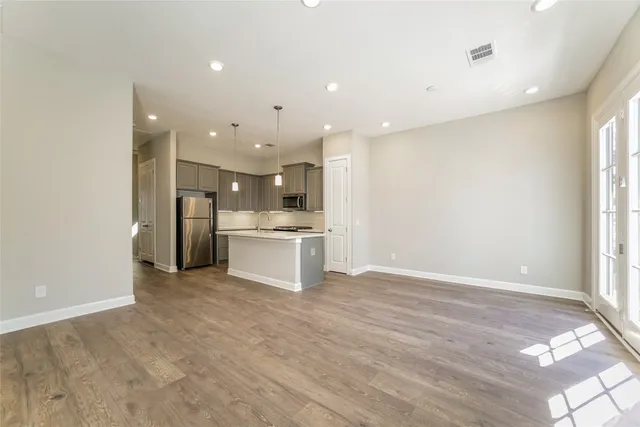 a view of a kitchen with a sink and dishwasher a refrigerator with wooden floor