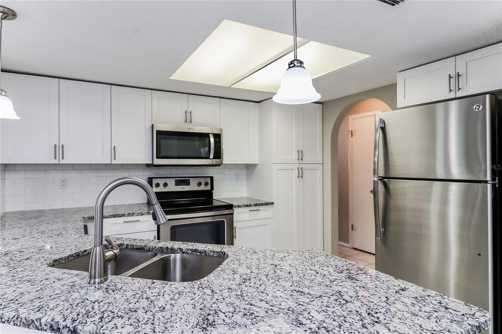 Undisclosed Address Spring Hill, FL 34609 - Photo 6 of 15 a kitchen with granite countertop a refrigerator and a sink
