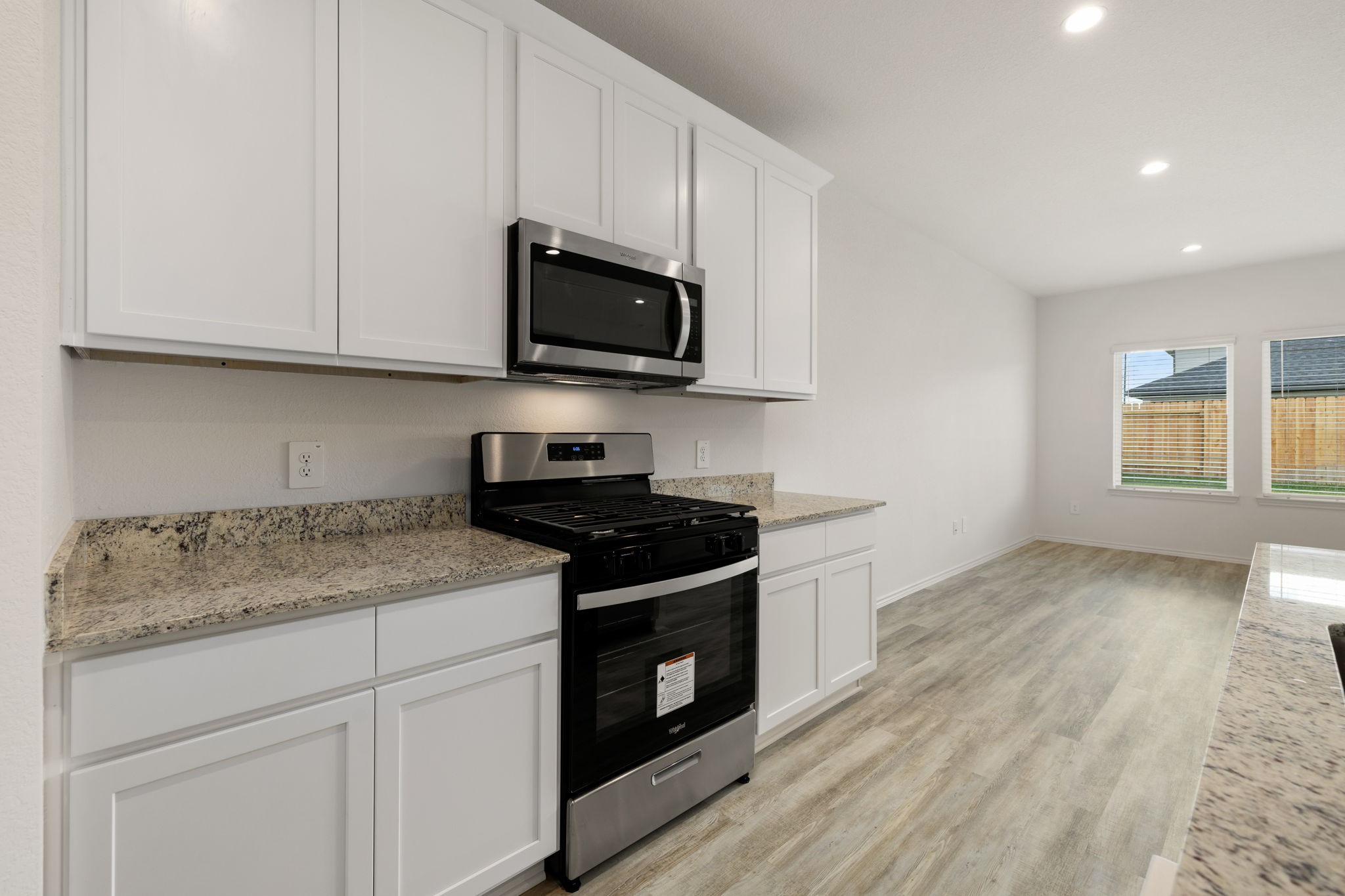 31007 Delamere Fulshear, TX 77441 - Photo 6 of 22 a kitchen with stainless steel appliances granite countertop white cabinets granite counter tops and a hard wood floors