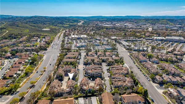 an aerial view of residential houses with outdoor space and trees