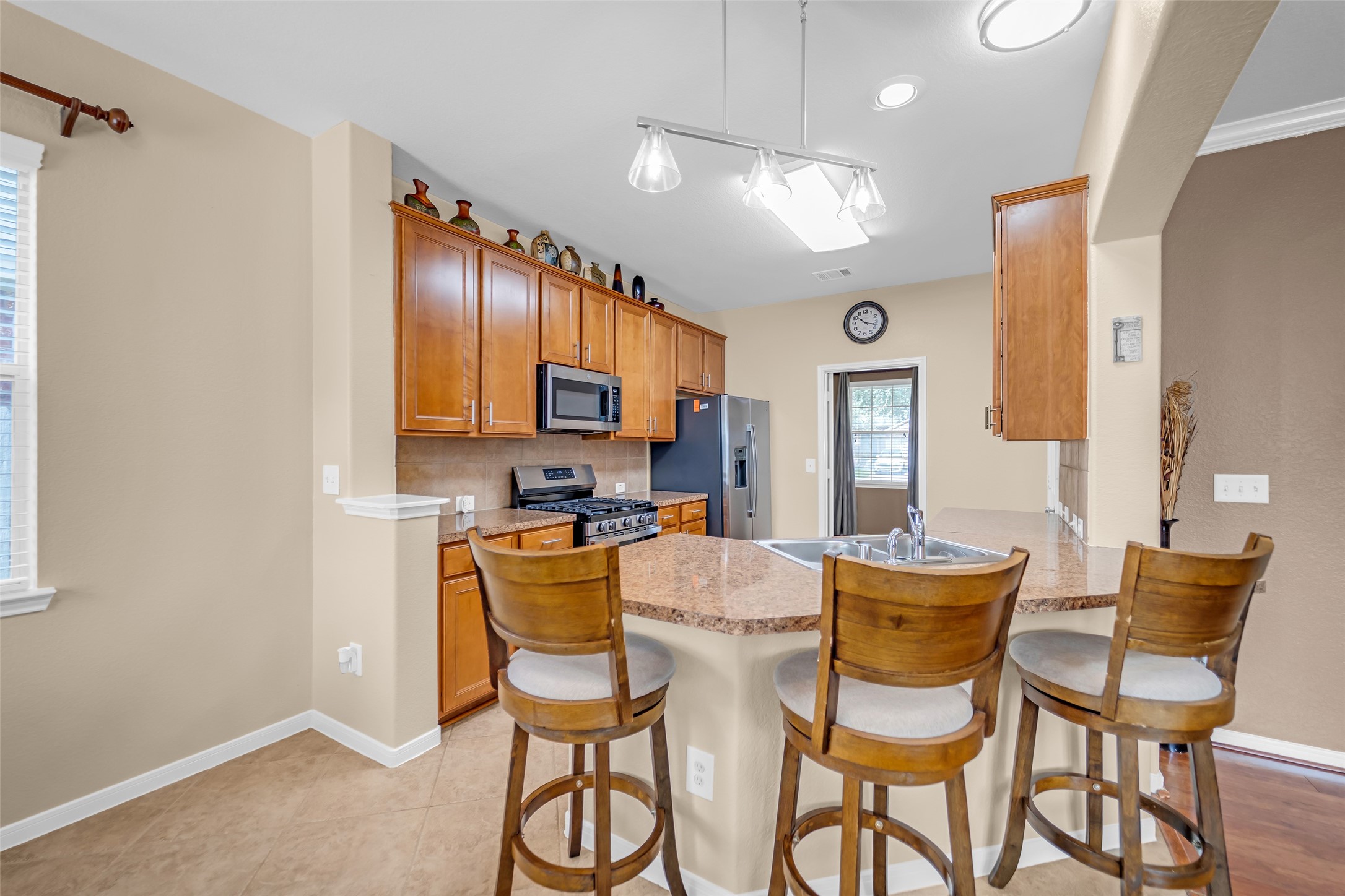 5406 Quarry Ridge Road Richmond, TX 77407 - Photo 15 of 36 Open-concept kitchen featuring an expansive breakfast bar with seating, abundant cabinetry, generous counter space, and a seamless connection to the breakfast area and main living spaces for easy everyday living and entertaining.