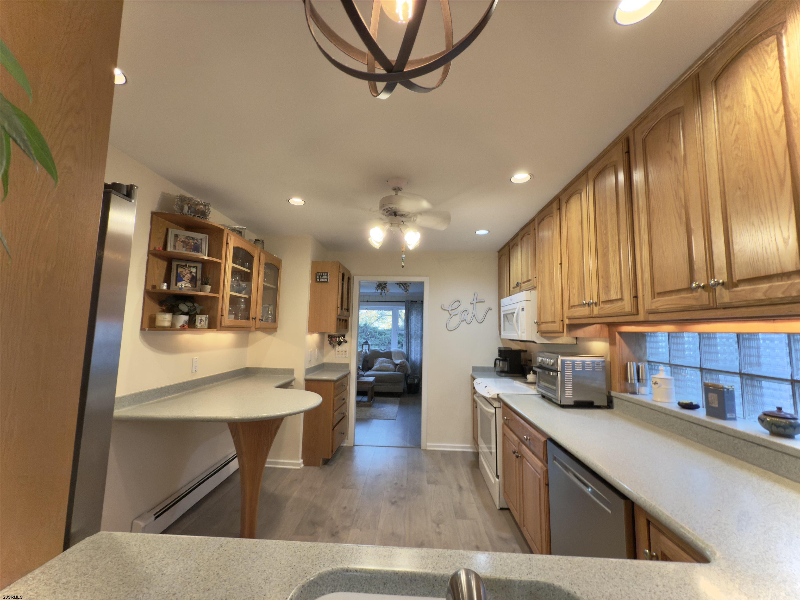 605 Shore Road Linwood, NJ 08221 - Photo 72 of 99 a kitchen with stainless steel appliances kitchen island granite countertop a refrigerator a stove and a sink with wooden floor