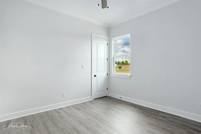 a view of empty room with window and wooden floor