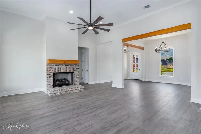 a view of an empty room with a window and fireplace