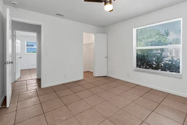 an empty room with windows and closet