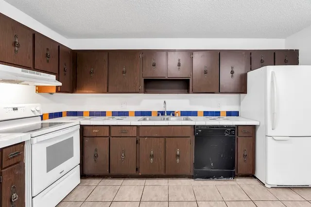 a kitchen with a cabinets and white appliances