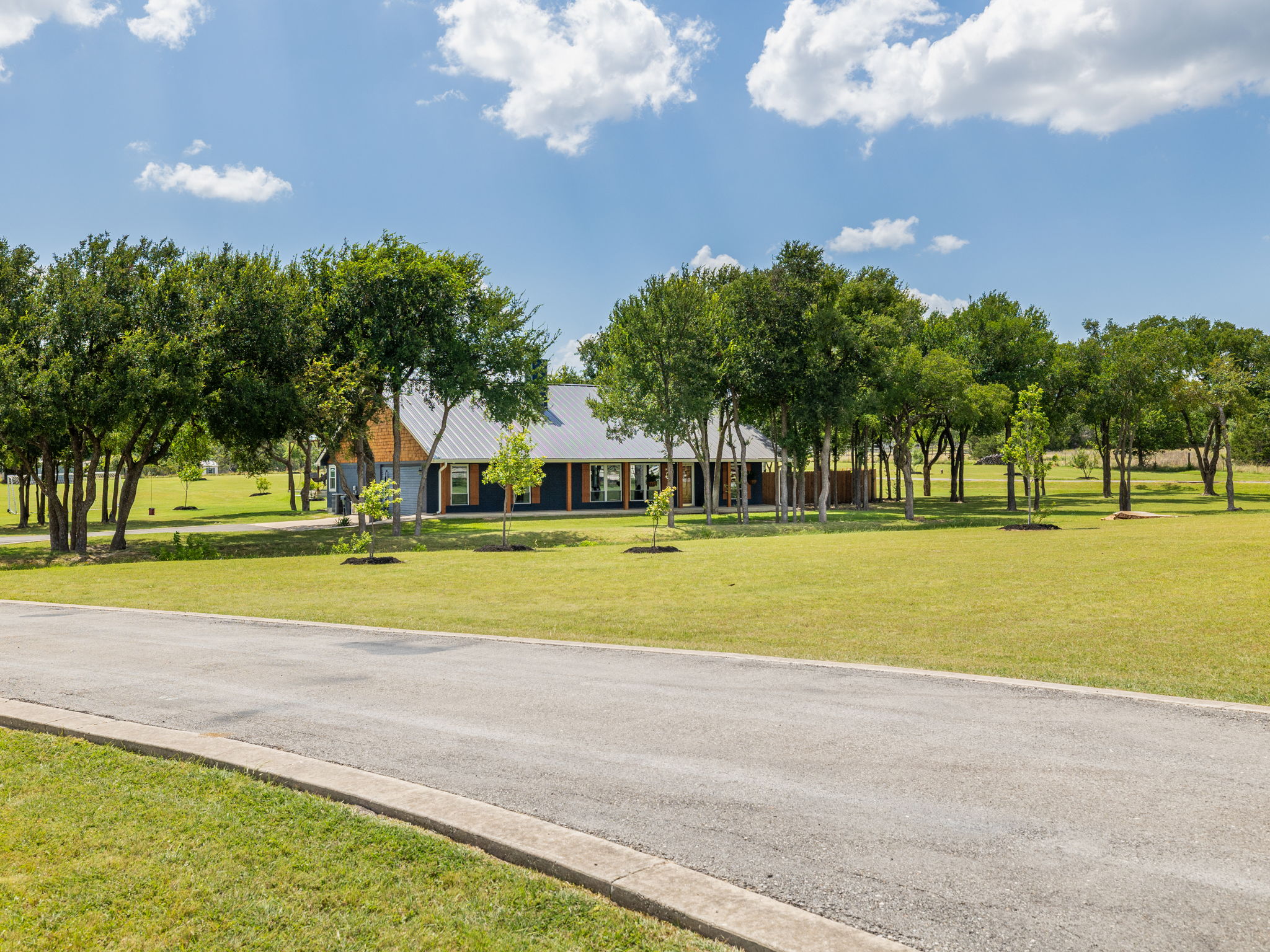 3001 County Road 255 Georgetown, TX 78633 - Photo 2 of 35 A graceful home nestled among mature trees on a sprawling, verdant property.