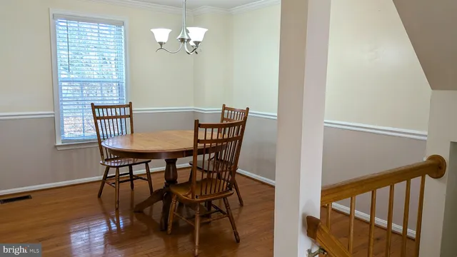 a view of a dining room with furniture a chandelier and wooden floor
